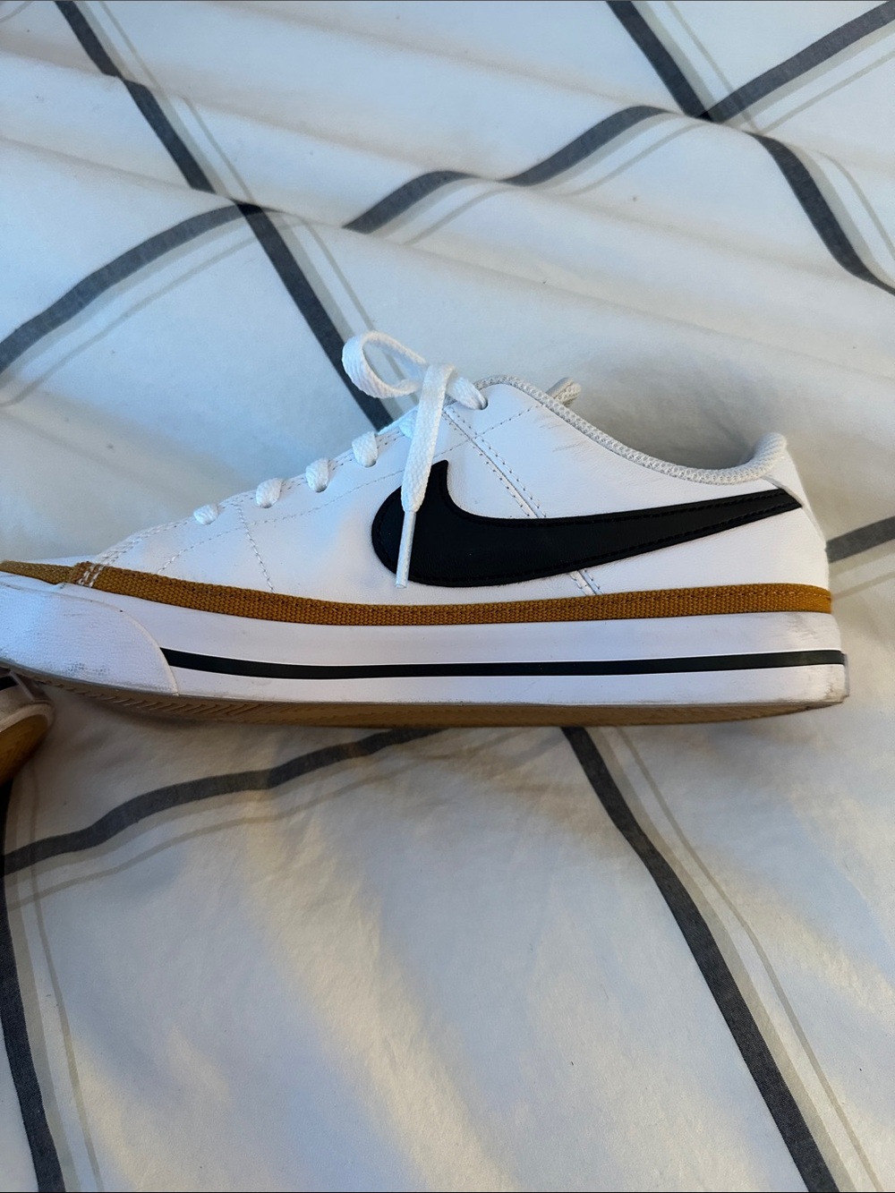 Nike White Low-Top Sneaker with Black Swoosh and Gold Trim